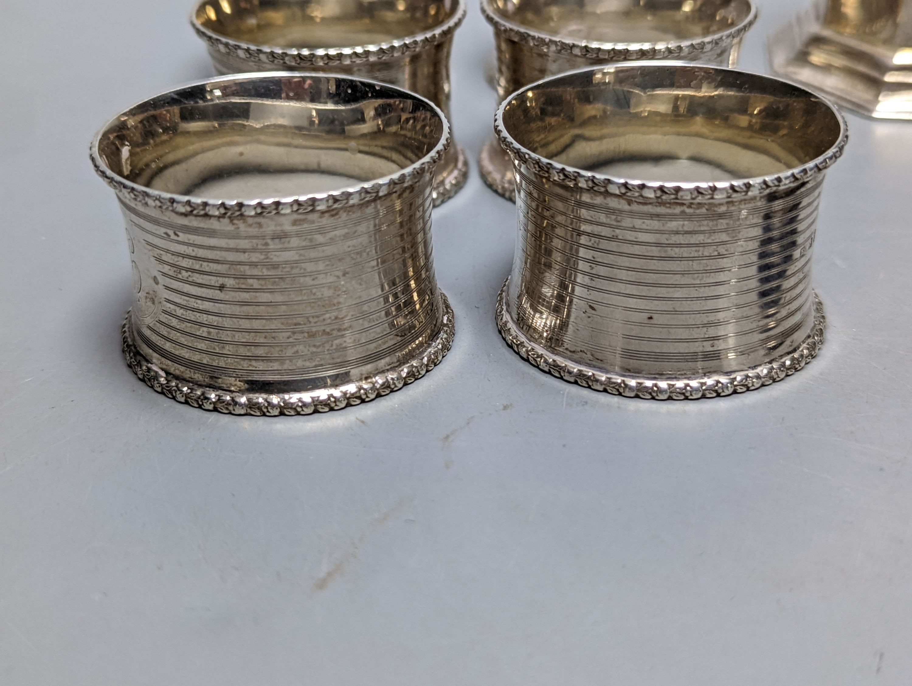 A set of six George V silver napkin rings, Birmingham, 1915, a silver sugar caster and silver butter knife.